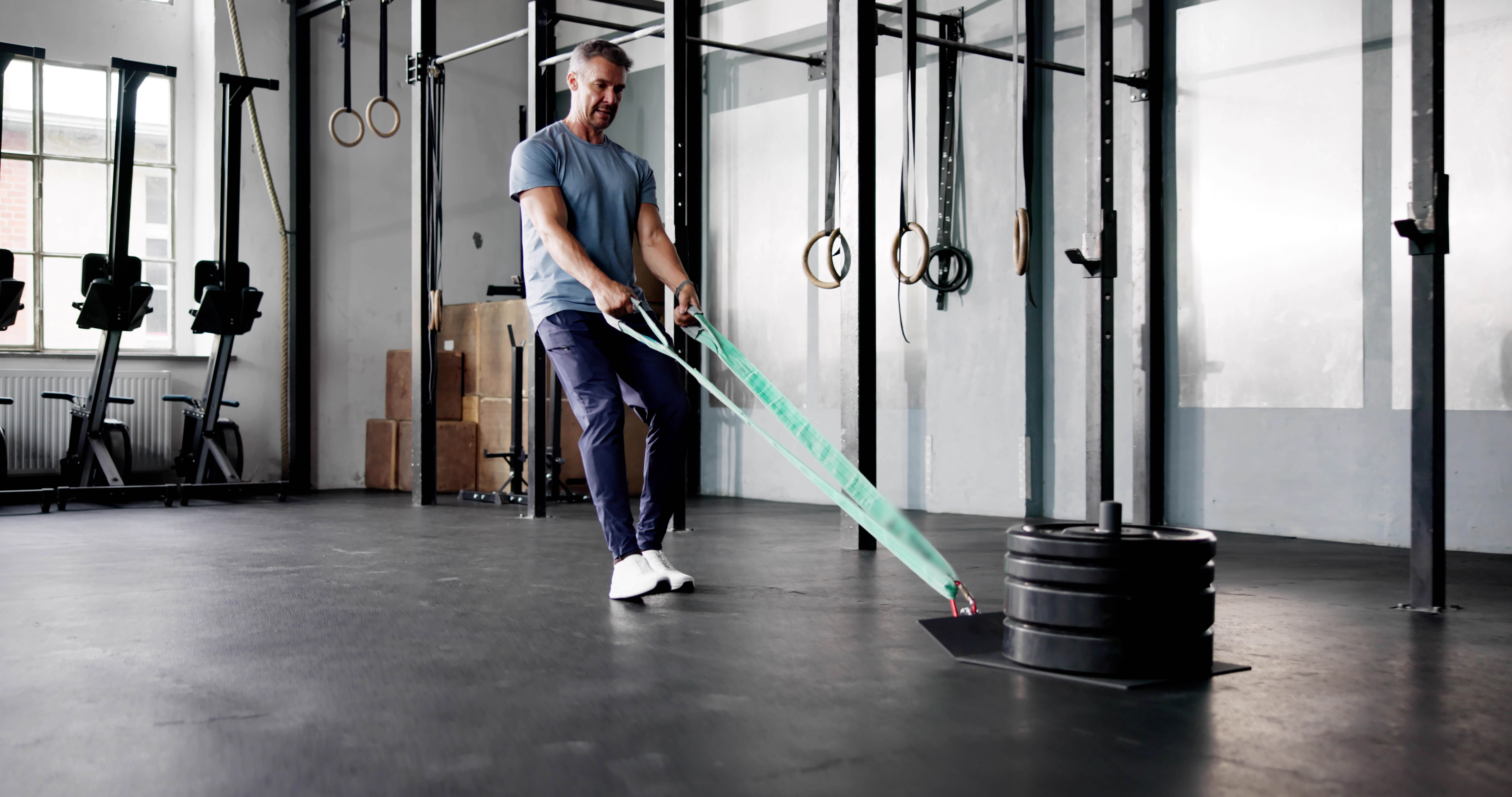 Man doing a backwards sled pull in a gym